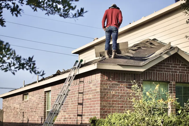 Professional roofer working on a residential roof in Portales
